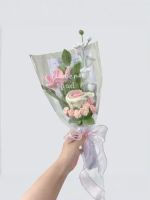 Woman holding pastel crocheted flower bouquet
